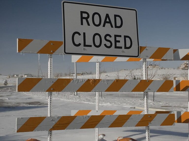 Road sign closed due to heavy snow and slippery affecting travel